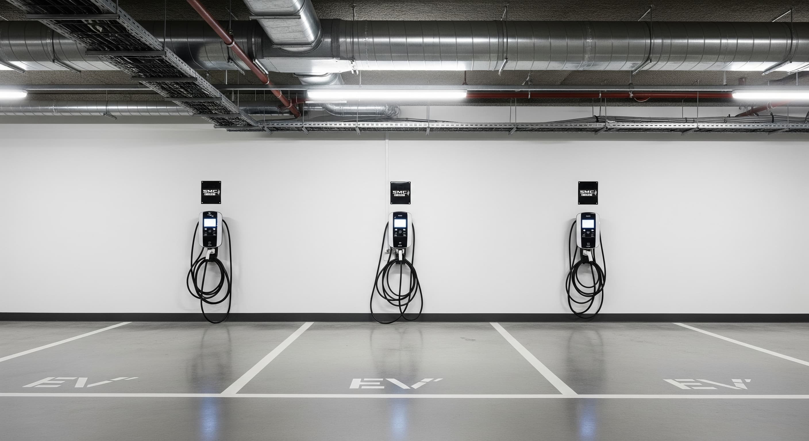 A row of modern EV chargers in a commercial car park